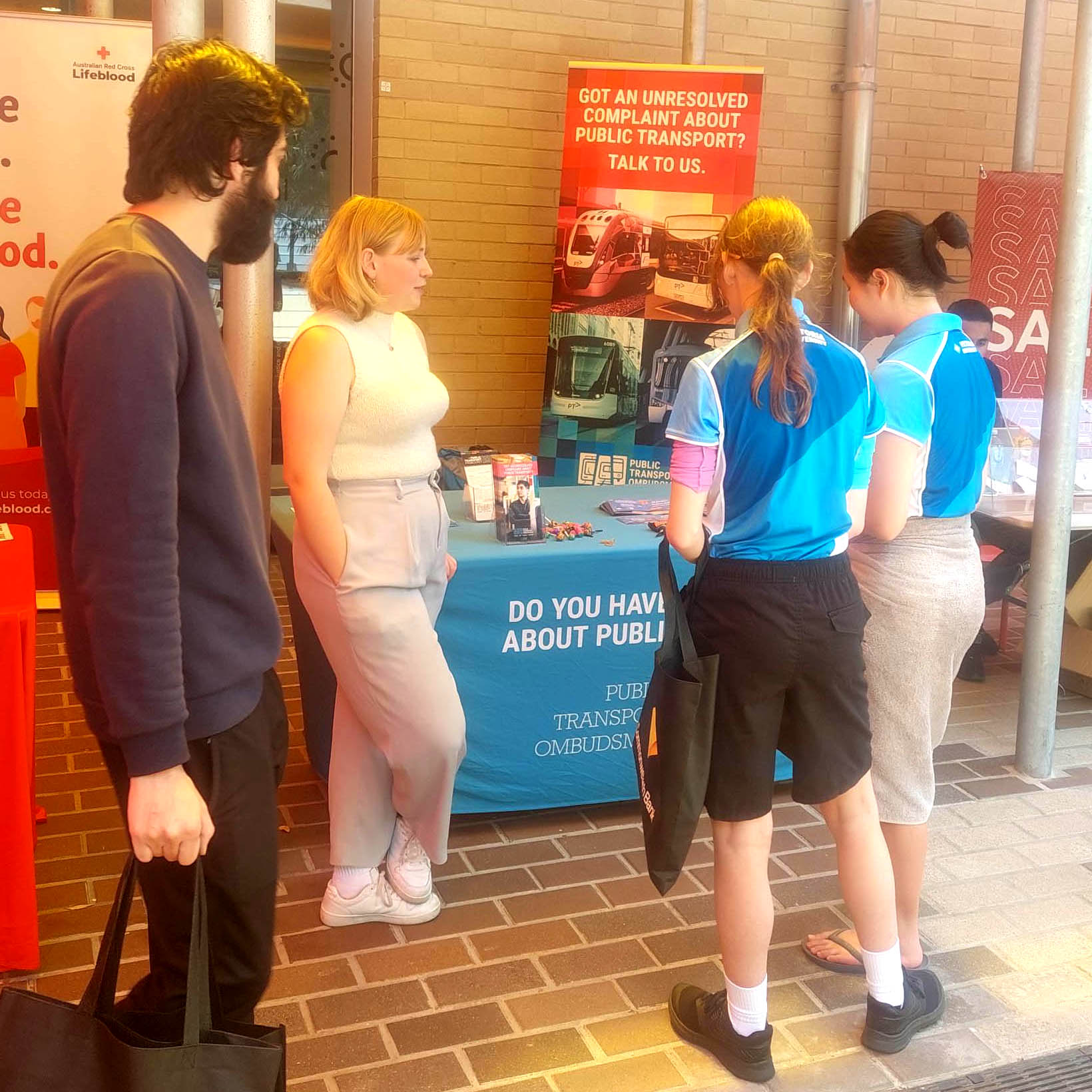 A group of people standing around a PTO information stall at a Victoria University Open Day.