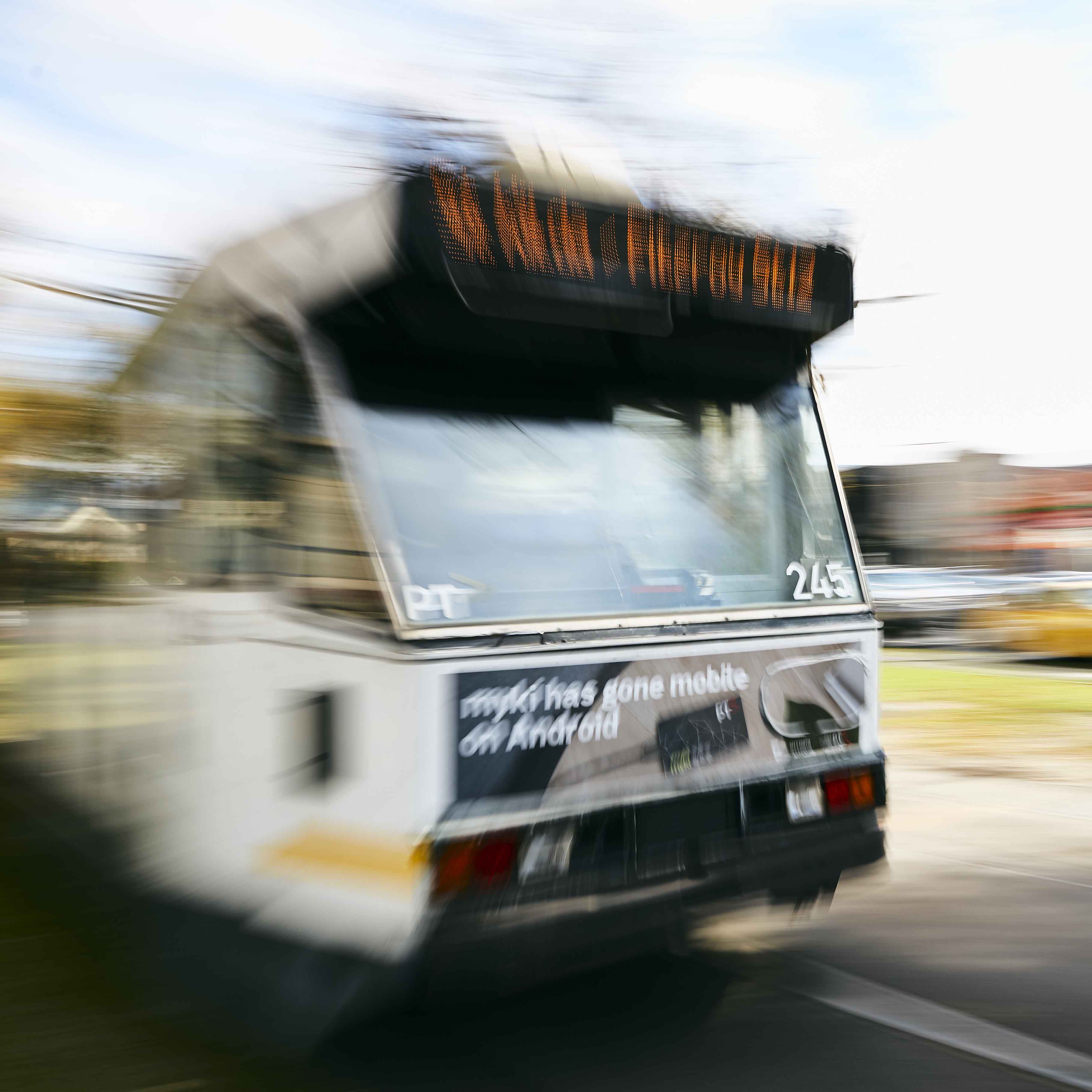 Image shows a blurred tram in motion as it passes by. 