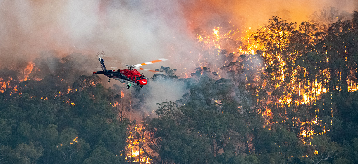 Photograph shows a firefighting helicopter at the Mallacoota fire.